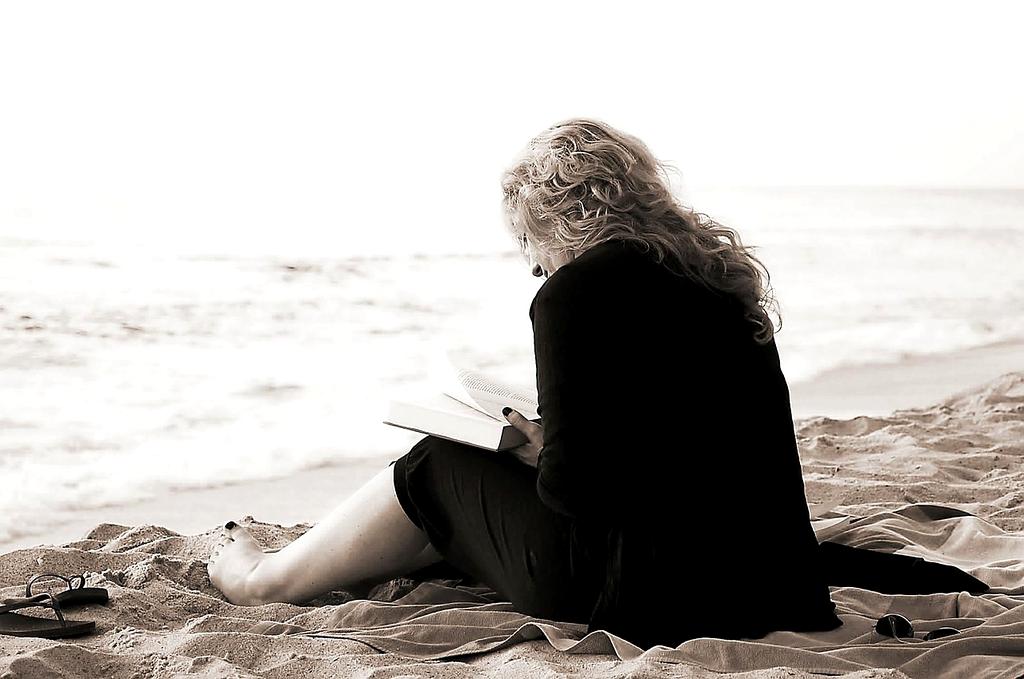 Stack of cultural travel books and global maps on a wooden table